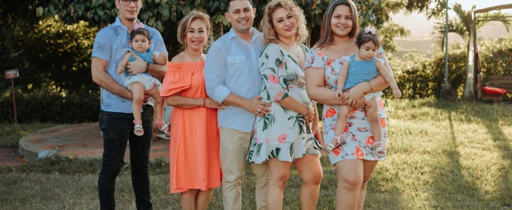 A joyful family posing together outdoors at sunset in a park.
