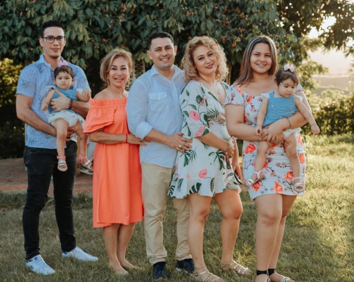 A joyful family posing together outdoors at sunset in a park.